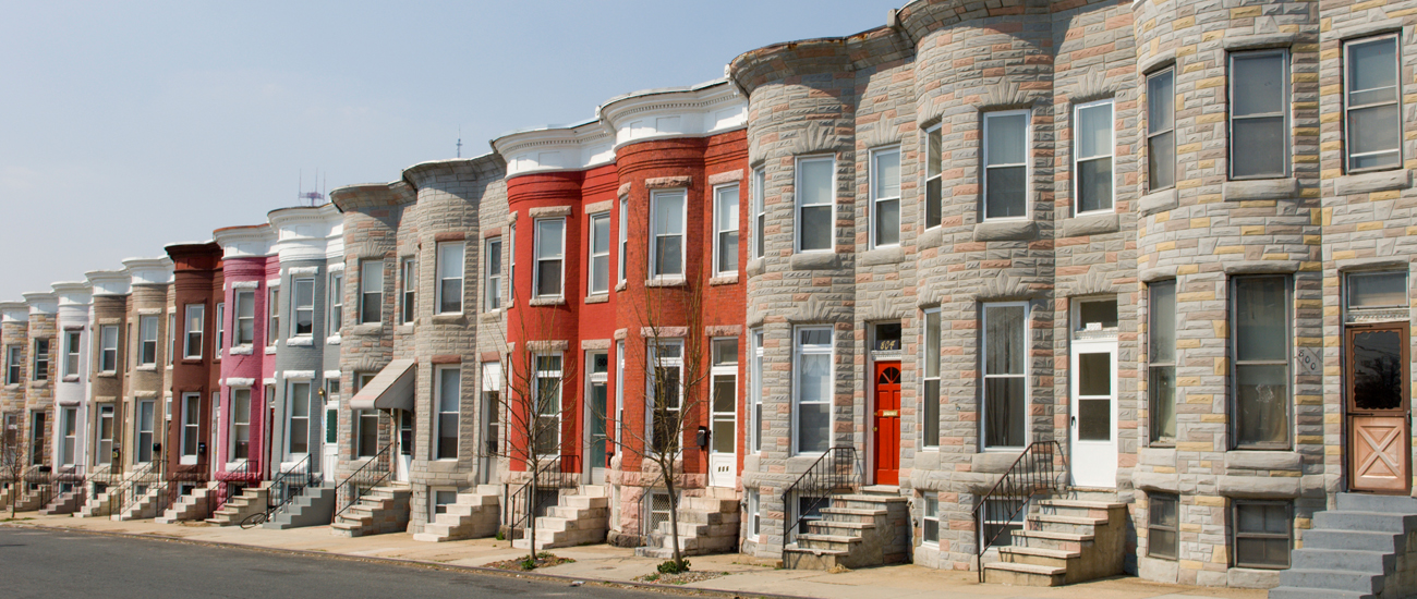A row of traditional townhouses with distinctive stone facades and colorful doors.